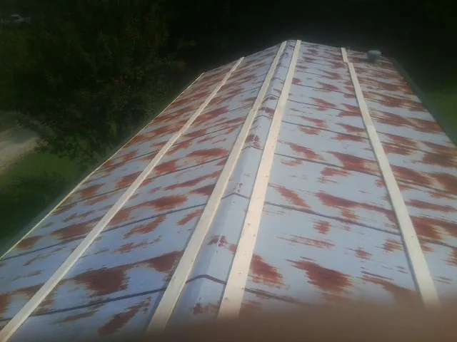 Rusted metal roof panels with new wood purlins before replacement — Storm Damage Roof Repair in Metz by Roofing Brothers